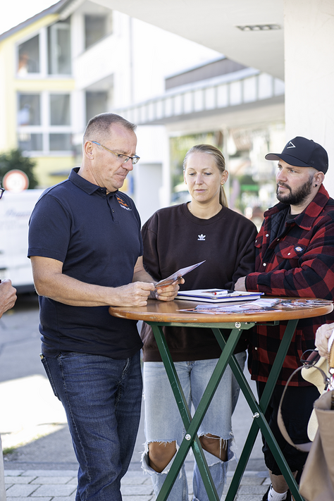 Gemeinsam im Gespräch in Dettenhausen Daniel Gruner und mehrere Besucher stehen gemeinsam am Infostand in Dettenhausen.